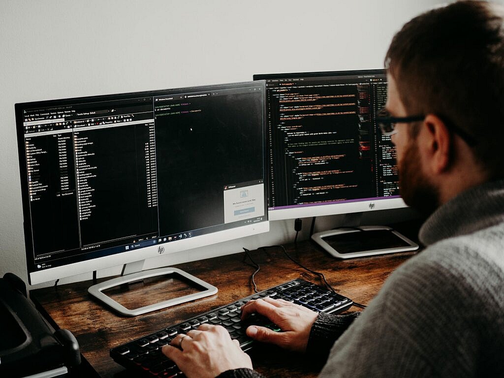 se1free photo of man working on computers coding