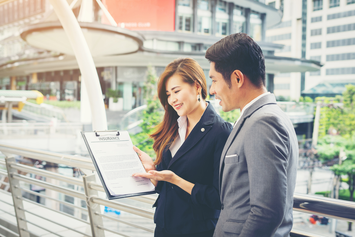 2025年最新【Web マーケティング発注完全ガイド】業者選定から成果管理まで 16 business man pointing document with smile discussing something with her coworker while standing front office 1