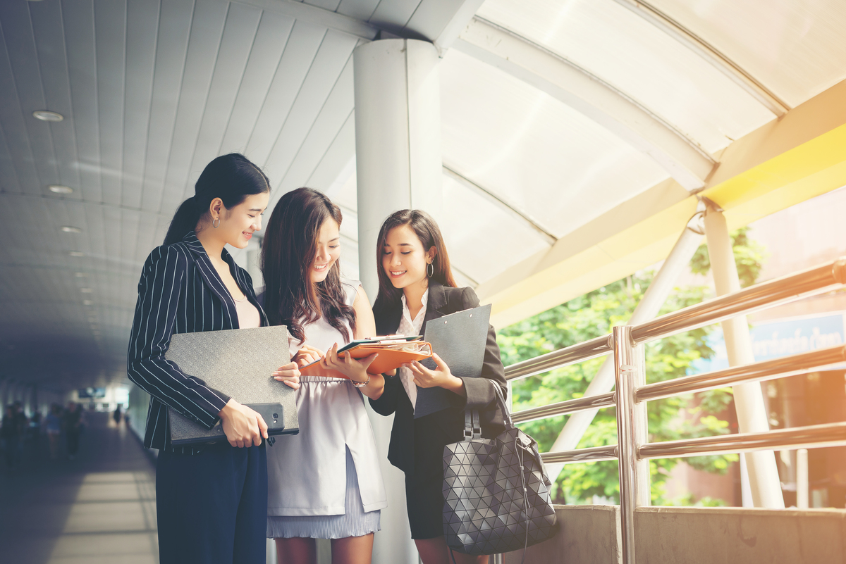 2025年最新【Webマーケティング未経験者】失敗しないスクールの選び方・活用術 32 businesswomen discussing paperwork together against railing business people concept 2